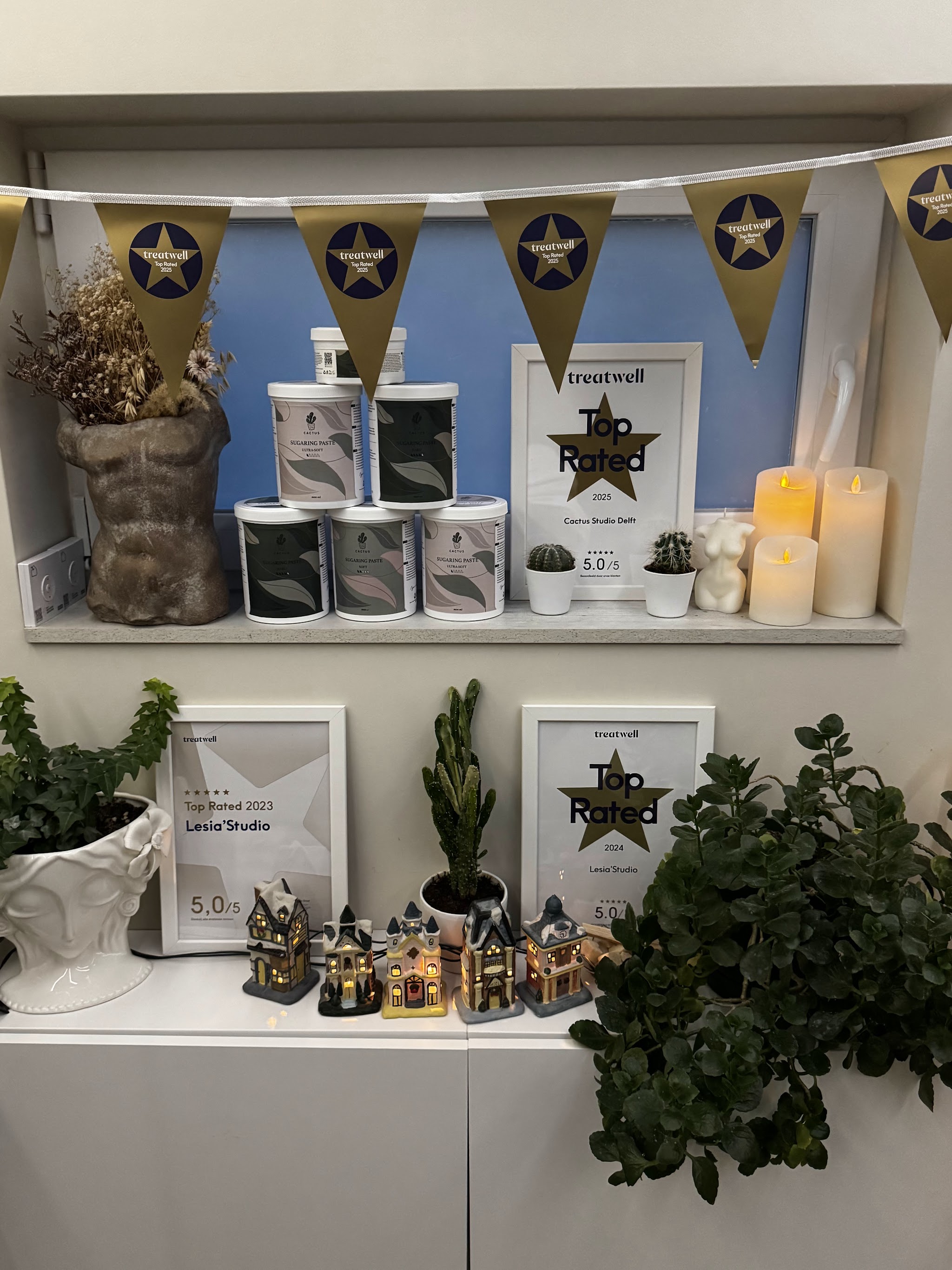 Plank in de studio met de Top Rated-oorkondes van Treatwell, vlaggetjes, kaarsjes en potten suikerpasta